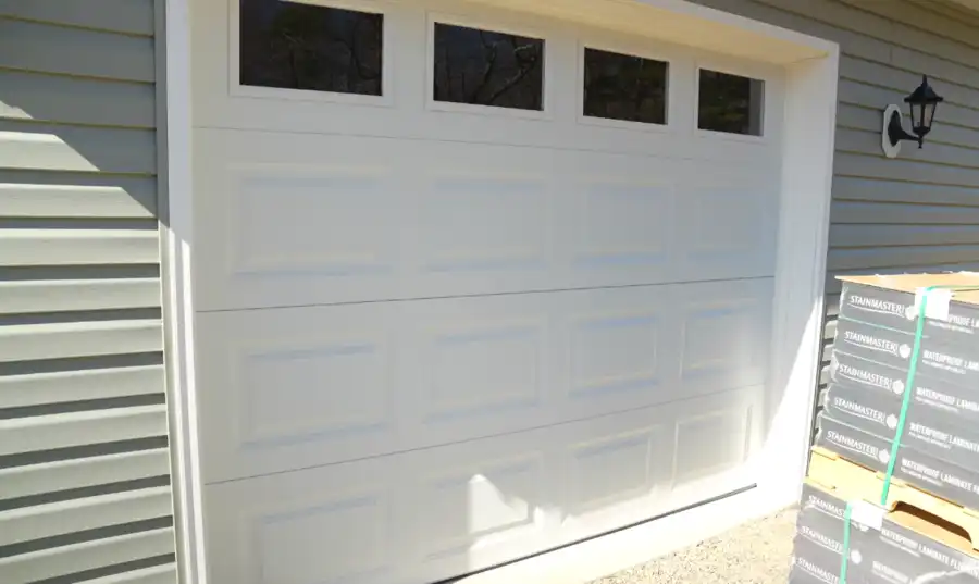 Traditional white raised-panel garage door with window inserts installed on a Visalia, CA home